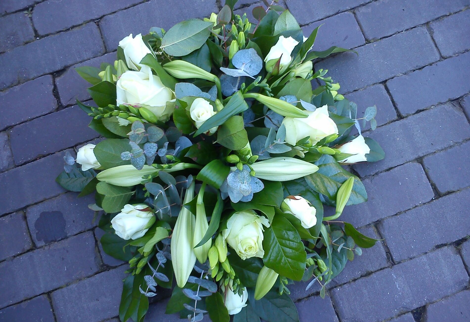 Wit rouwstuk met lelies en anthuriums